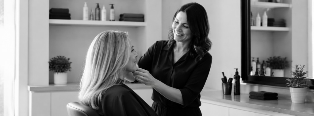 Beauty professional providing personal care service to a client in a salon