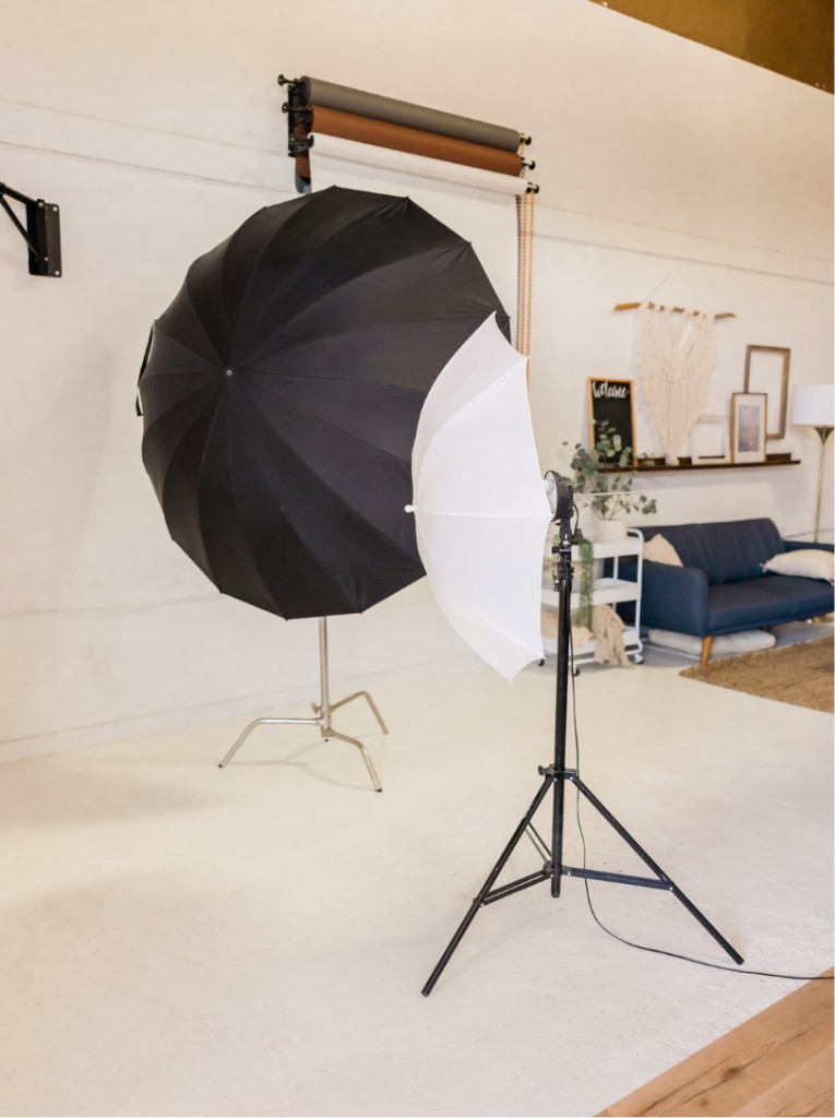 Professional photography studio with lighting equipment, backdrops, and a styled product shoot set